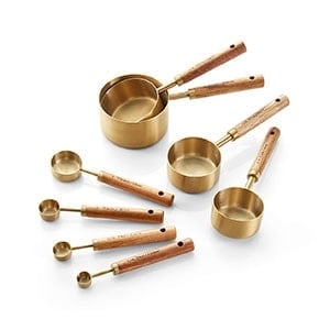 gold measuring spoons with wooden handles.