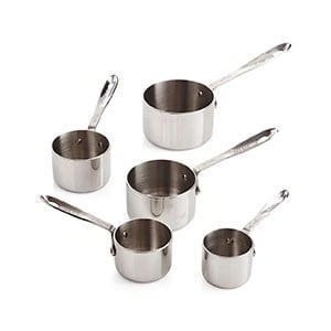 four stainless steel measuring cups on a white background.