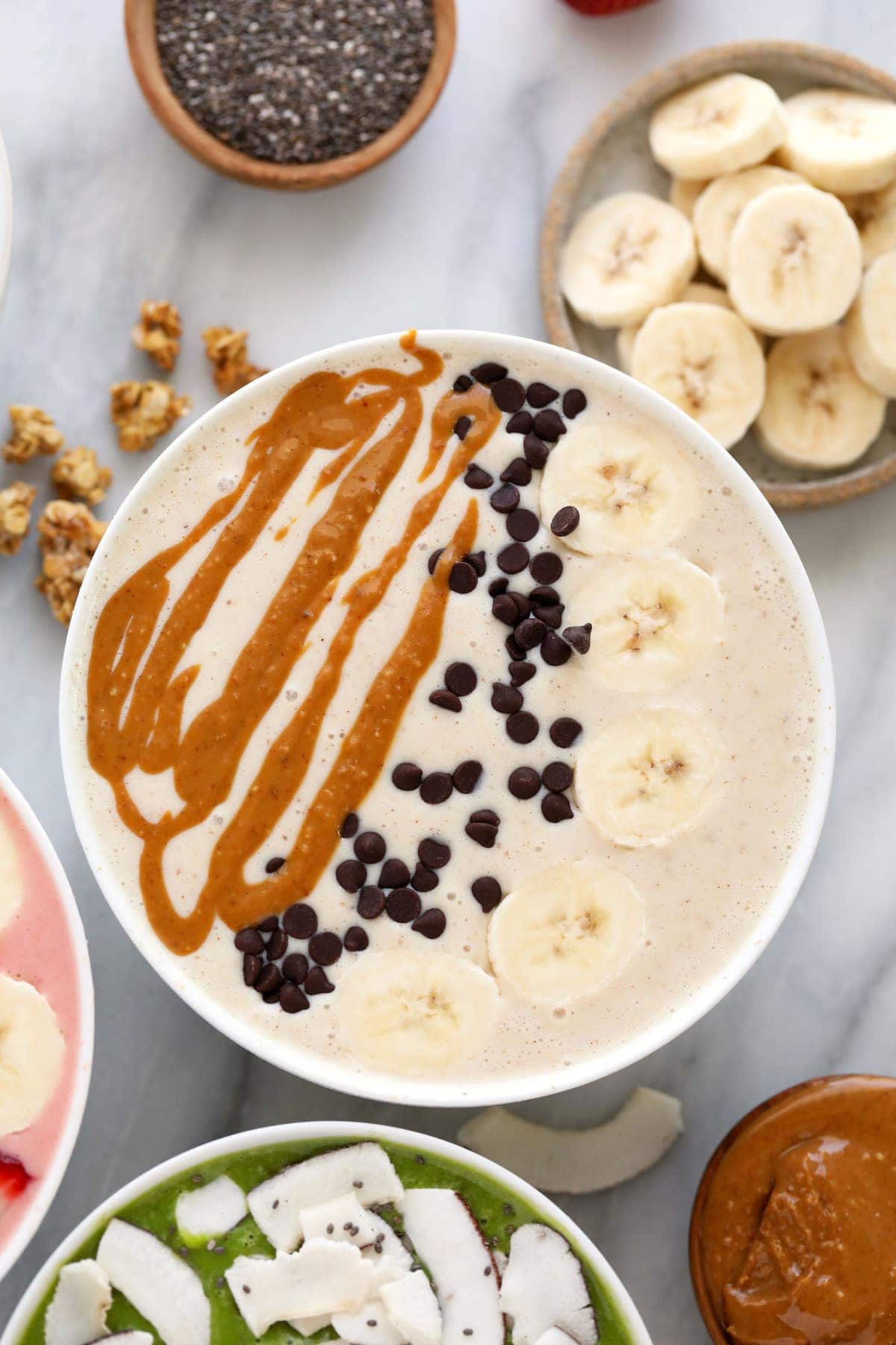 peanut butter banana smoothie bowl with mini chocolate chips, banana, and peanut butter