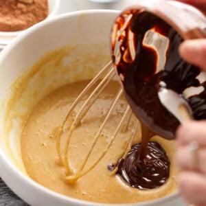 a person whisking a chocolate sauce into a bowl.