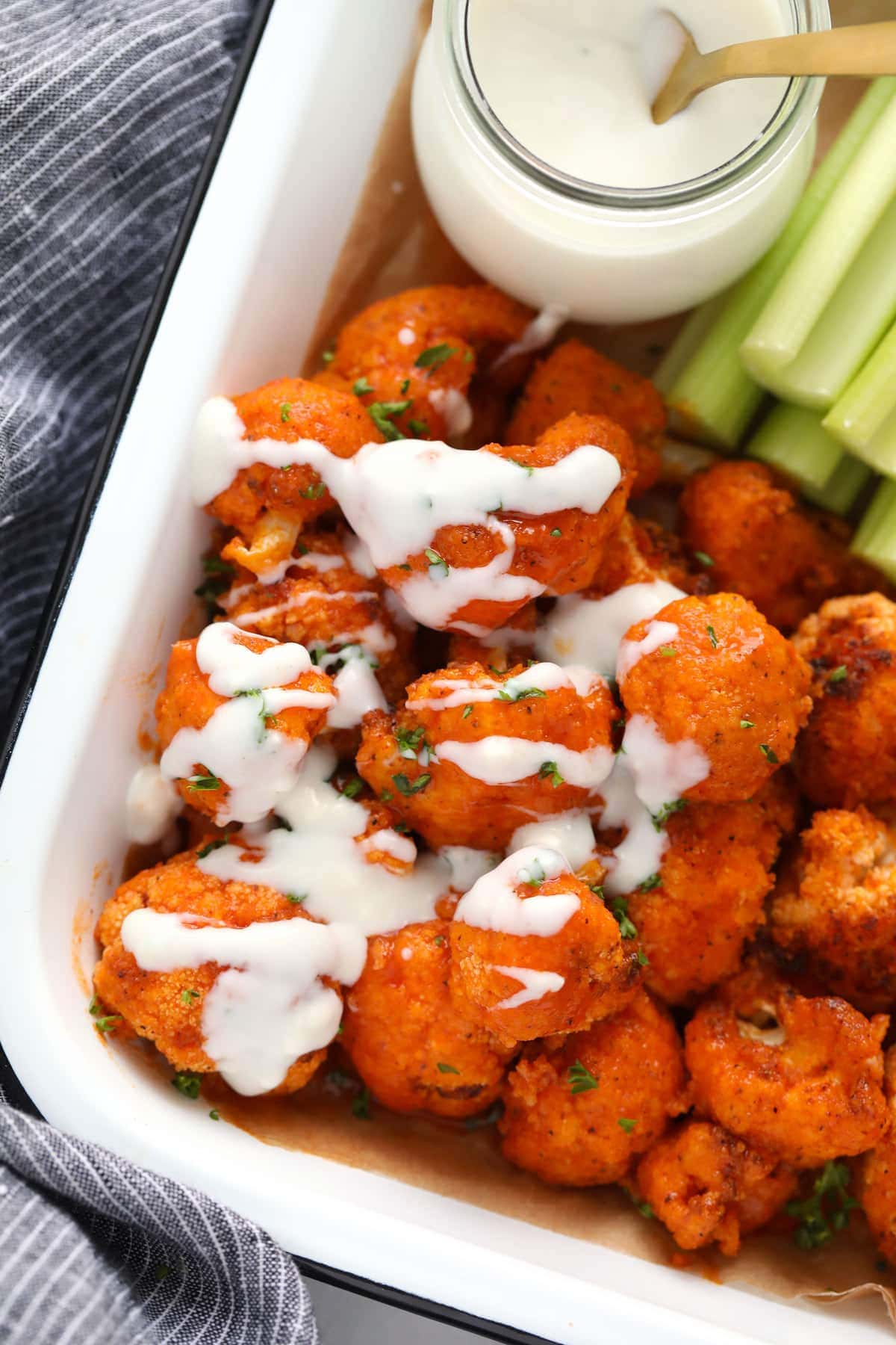 blue cheese sauce drizzled on buffalo cauliflower wings