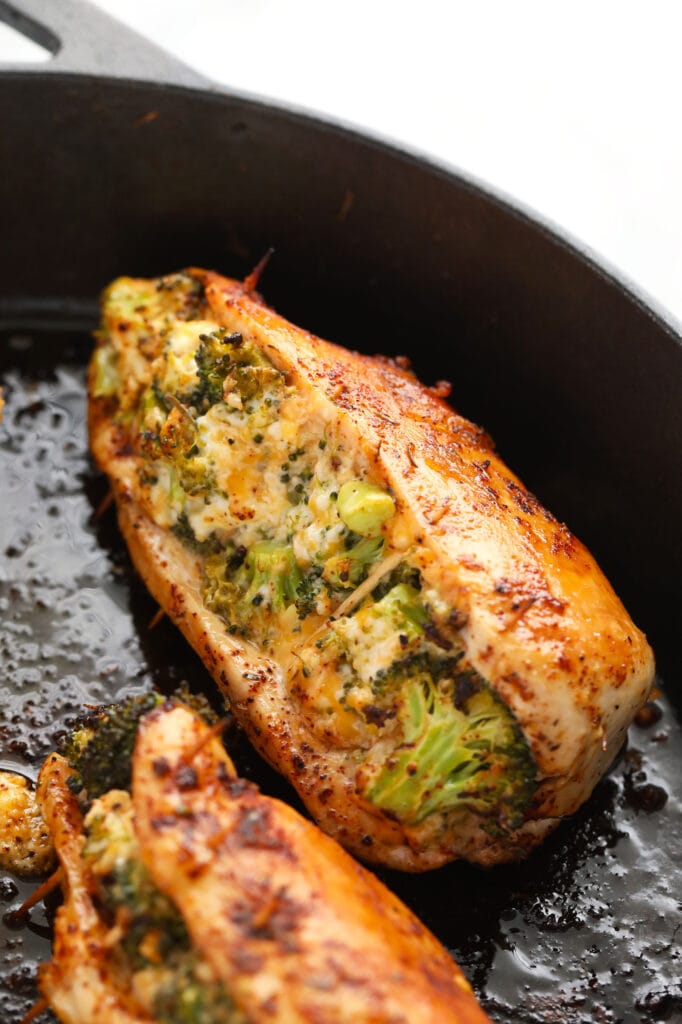 broccoli and cheese stuffed chicken breasts in a cast iron skillet