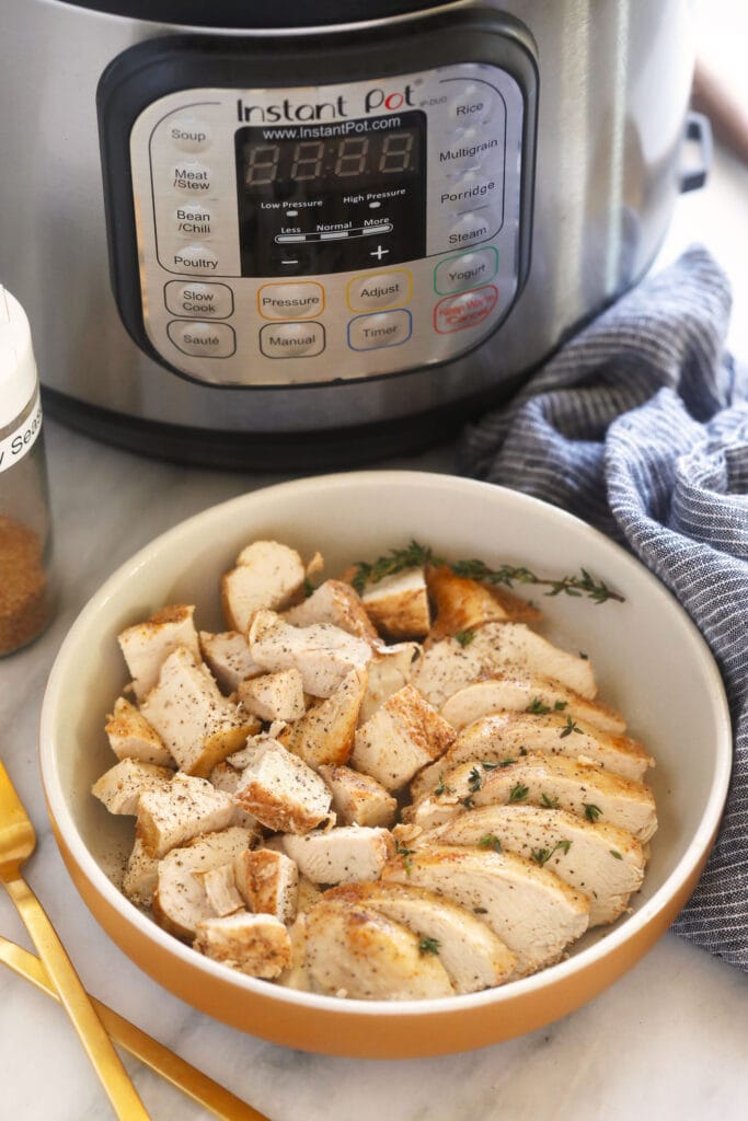 chicken in bowl next to Instant Pot