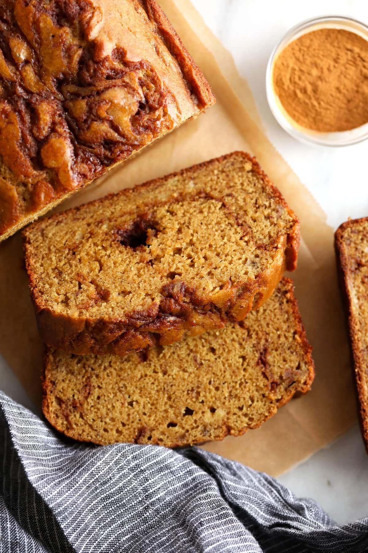 A piece of cinnamon swirl banana bread on cutting board. 