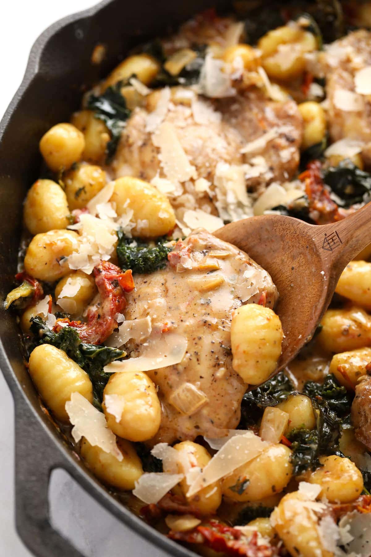 creamy tuscan chicken and gnocchi in a cast iron skillet