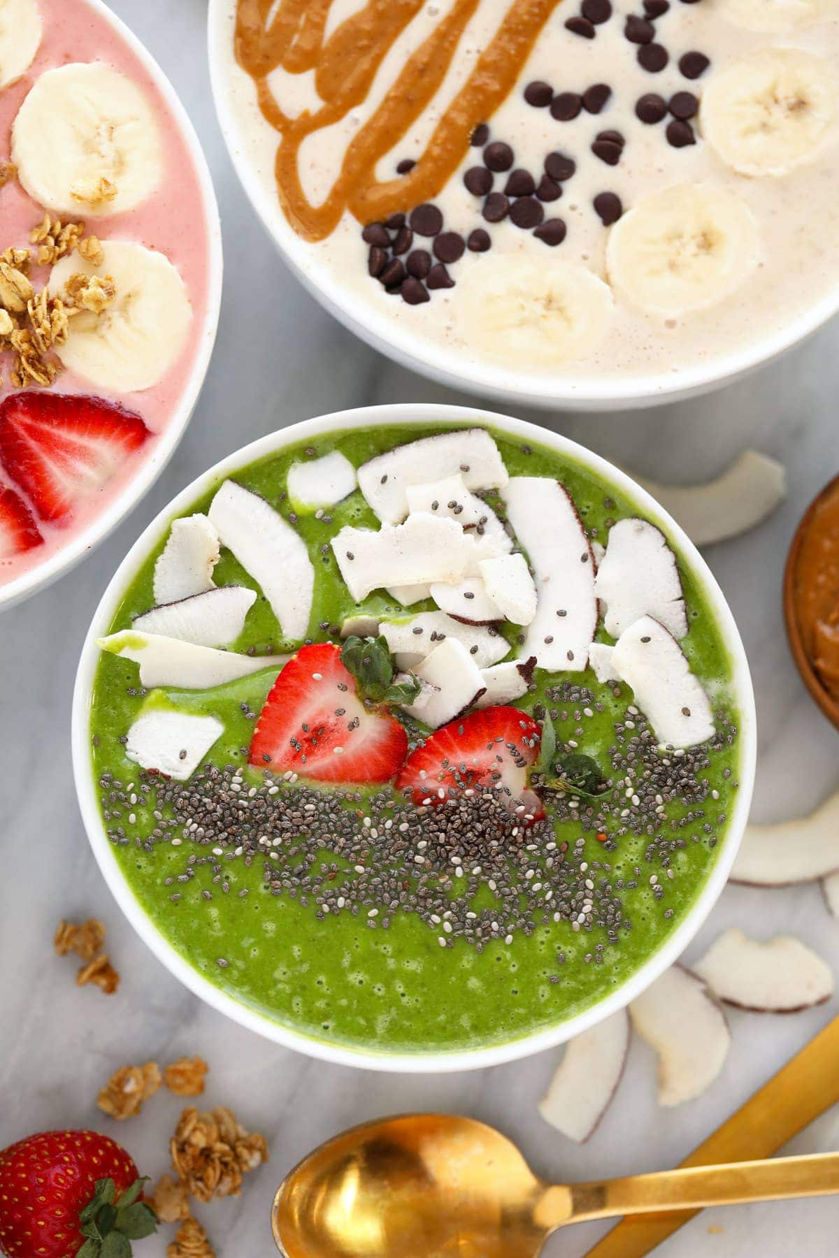 green smoothie bowl with strawberries, coconut, and chia seeds