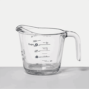 a glass measuring cup on a white surface.