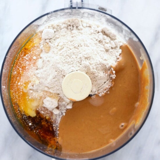 a food processor filled with ingredients for a peanut butter protein bar.