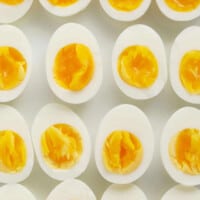 A group of hard boiled eggs on a white surface.