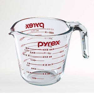a glass measuring cup with the word xex on it.