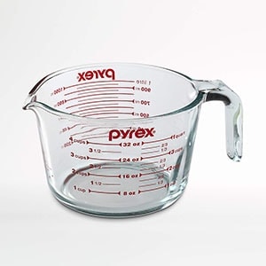 a glass measuring cup with the word xex on it.