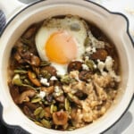 Savory oatmeal in a pot topped with a fried egg.