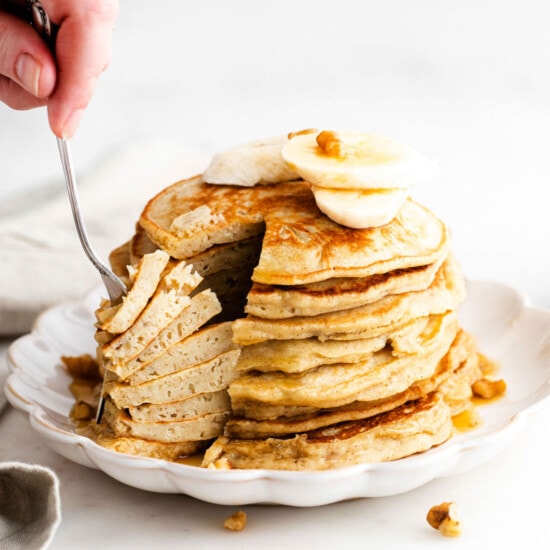 pancakes with bananas and walnuts on a plate.