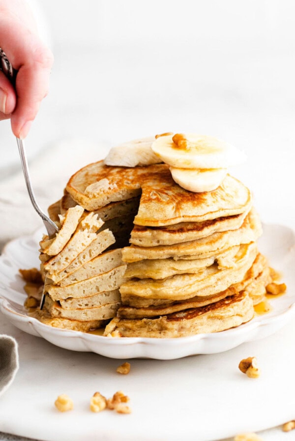 pancakes with bananas and walnuts on a plate.