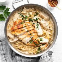 chicken and pasta in a pan with parsley and parmesan.