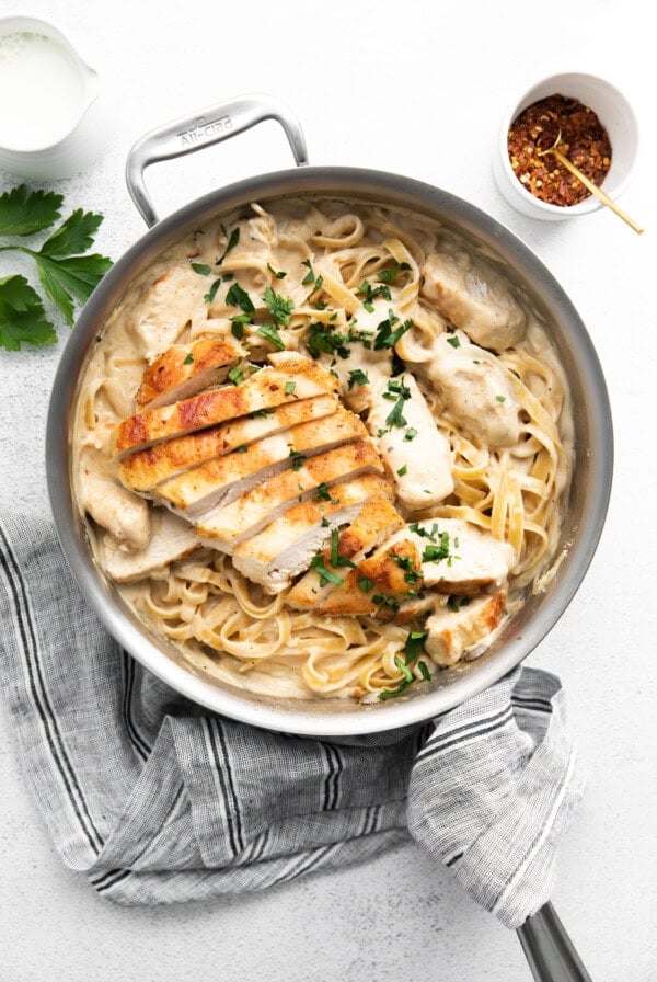 chicken and pasta in a skillet on a white background.