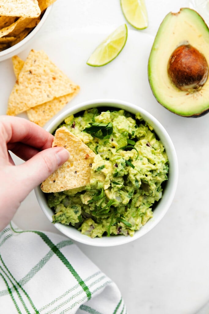 A tortilla chip scooping up guacamole. 
