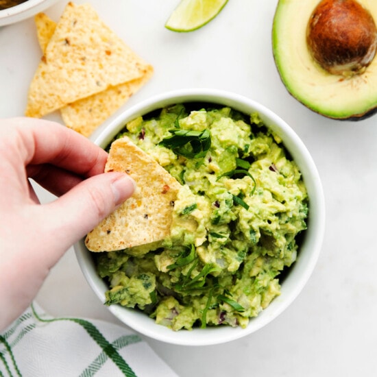 A tortilla chip scooping up guacamole