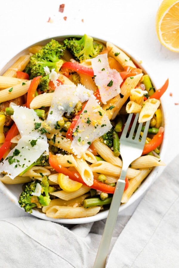 Pasta primavera with vegetables and a fork.