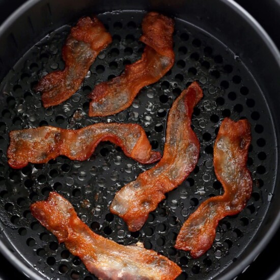 Bacon is being cooked in an air fryer.