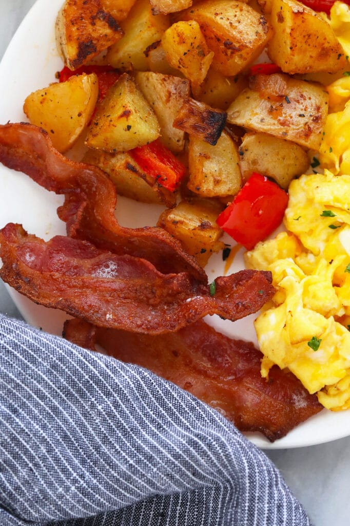 bacon with eggs and potatoes on plate
