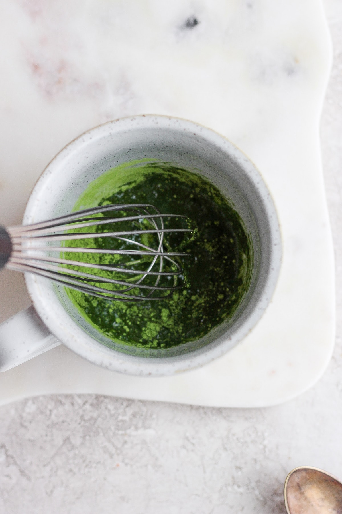 whisking matcha green tea powder with hot water