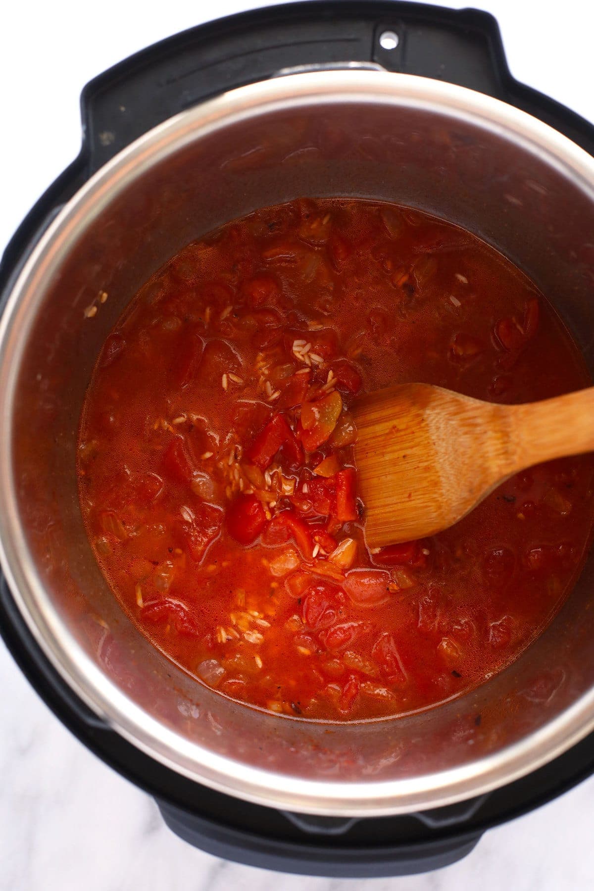 Liquid and other ingredients for Jambalaya in the Instant Pot. 