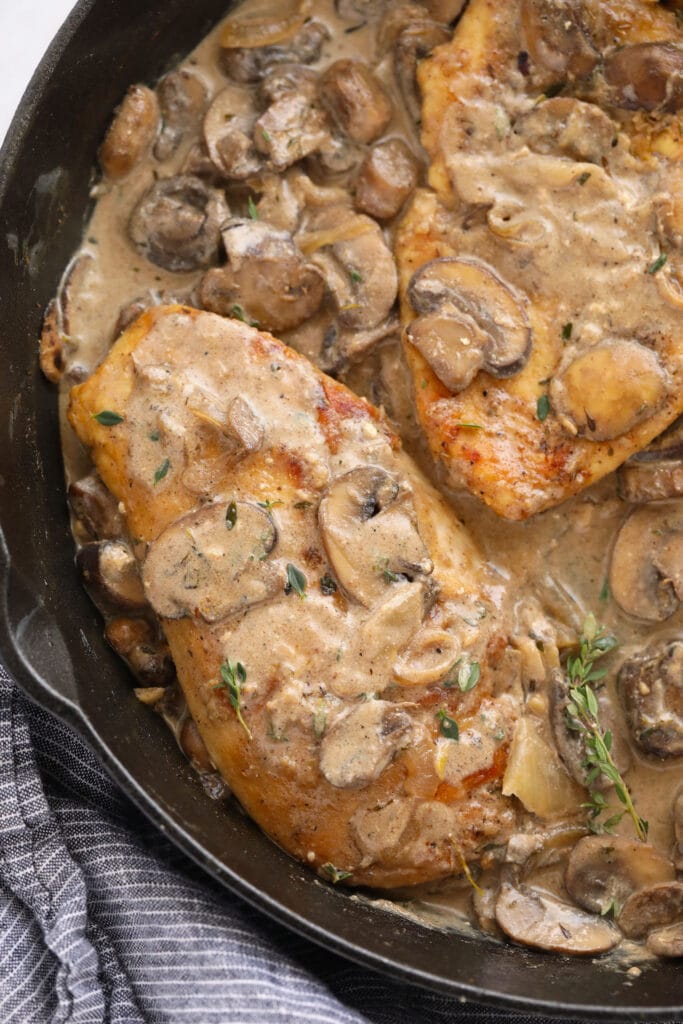 chicken marsala sauce poured over chicken breasts in a cast iron skillet