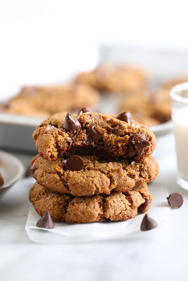 a stack of chocolate chip cookies with a glass of milk.