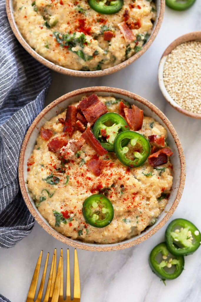 quinoa mac and cheese in a dish topped with jalapenos and bacon