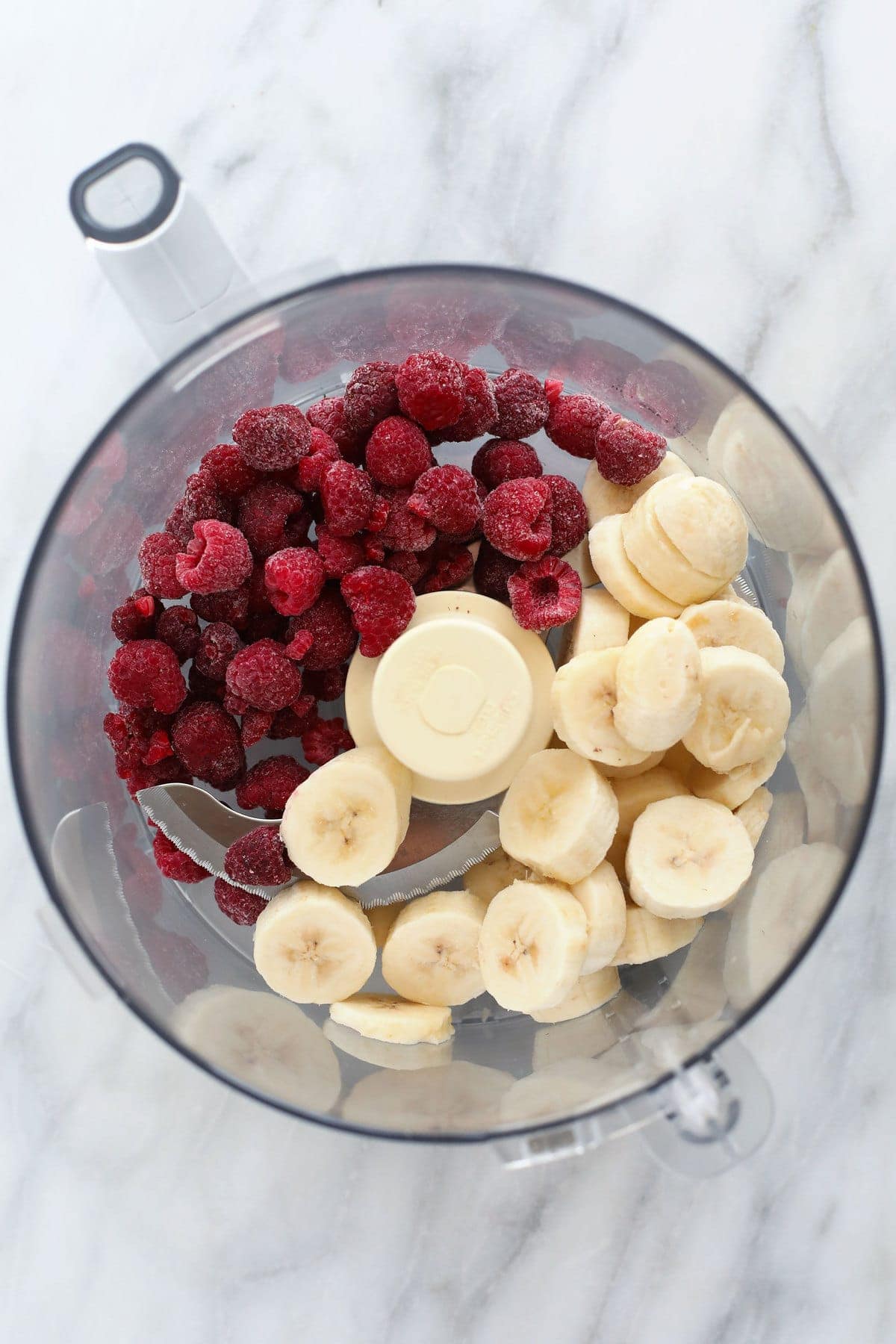 ingredients for raspberry chocolate chunk banana nice cream in a food processor