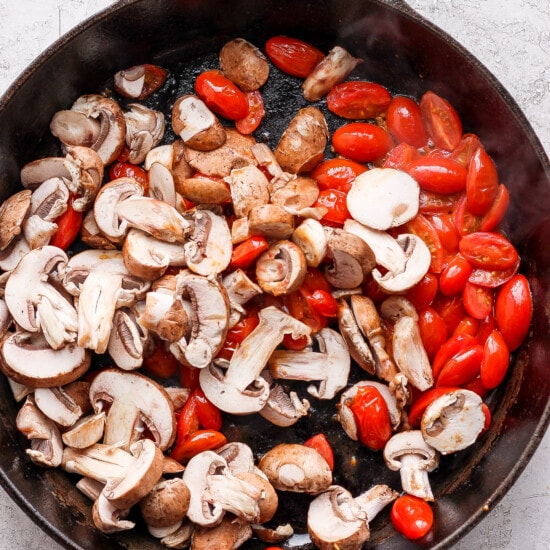 mushrooms and tomatoes in a skillet.