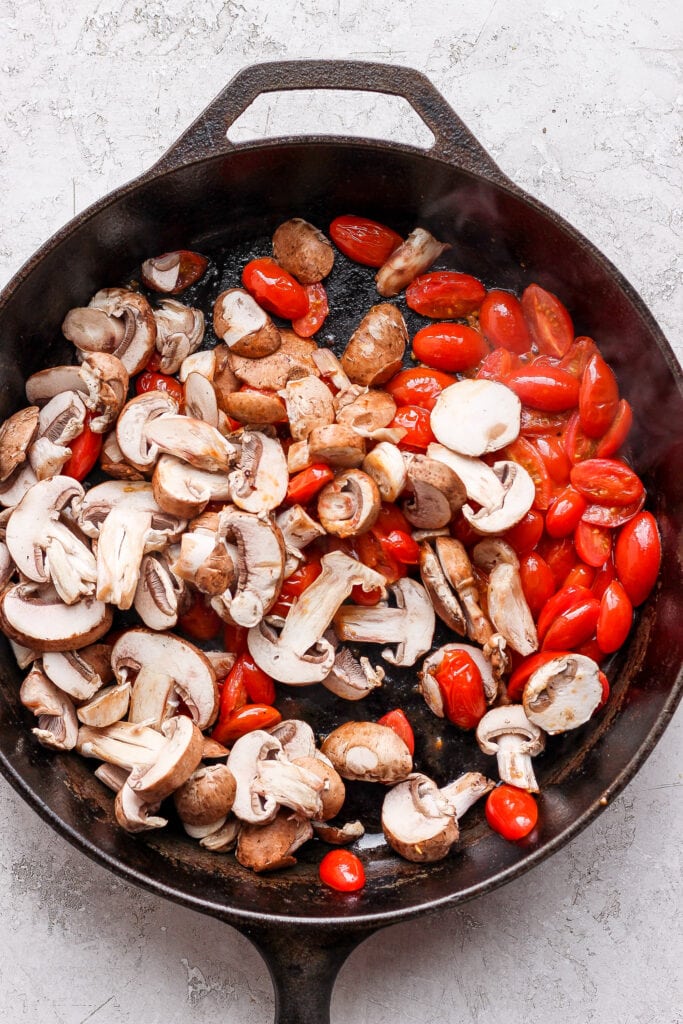 Tomatoes and mushrooms in a cast iron skillet. 