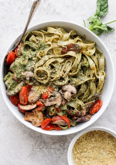 Pesto pasta in a bowl with vegetables.