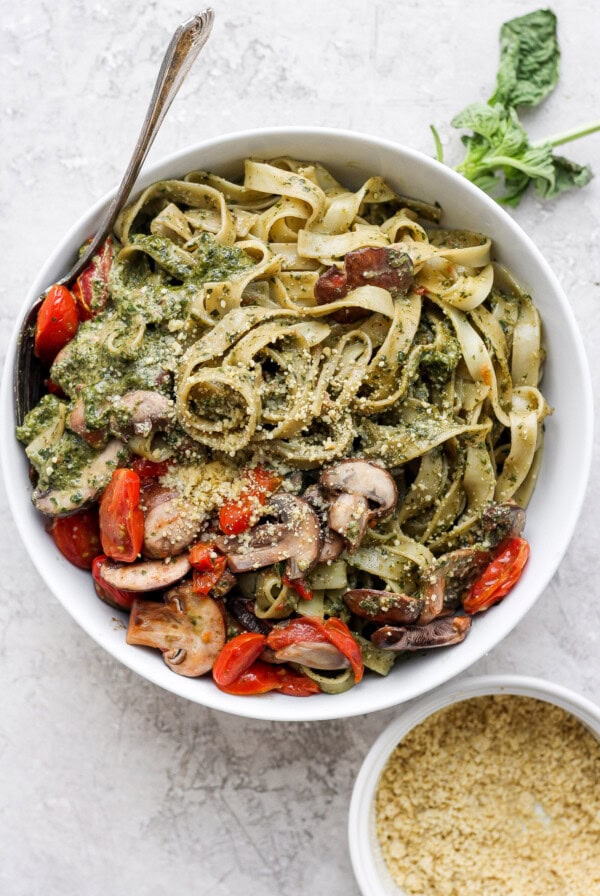 Pesto pasta in a bowl with vegetables.