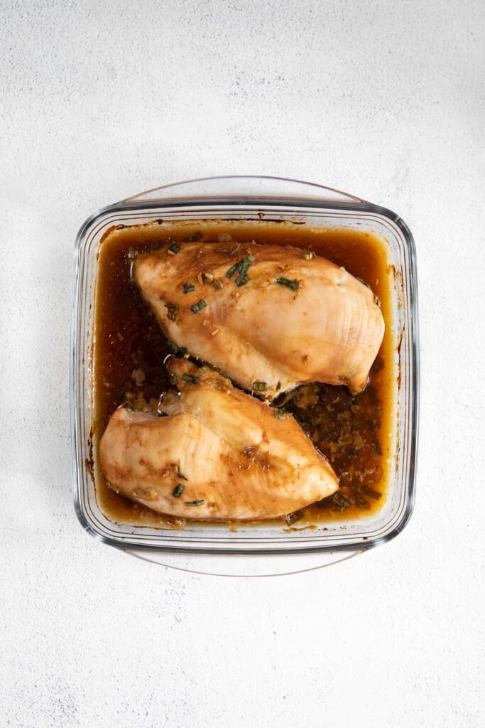 cooked chicken breast in casserole dish with sauce