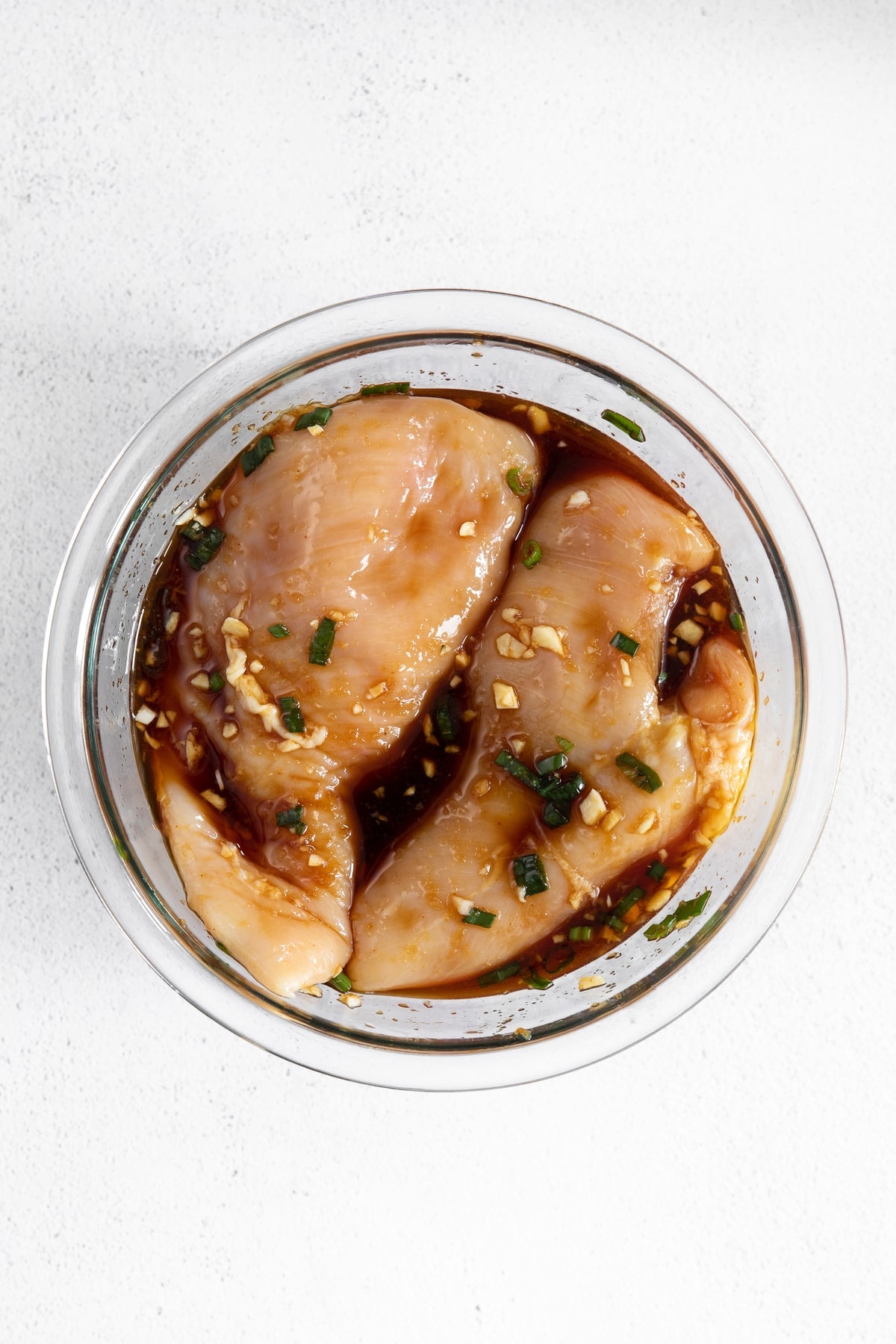 teriyaki chicken marinating in glass bowl