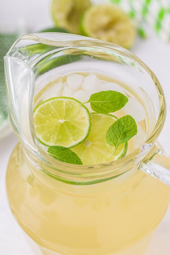 limeade in a pitcher with ice and fresh lime slices looking delicious