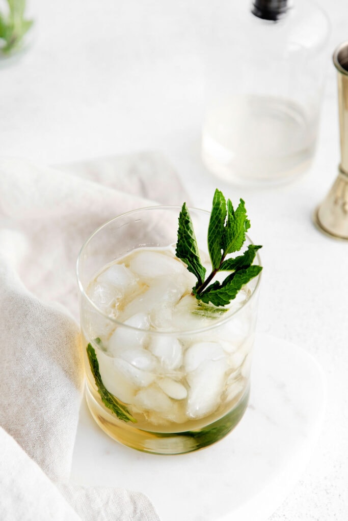 Mint julep in a glass, garnished with fresh mint.