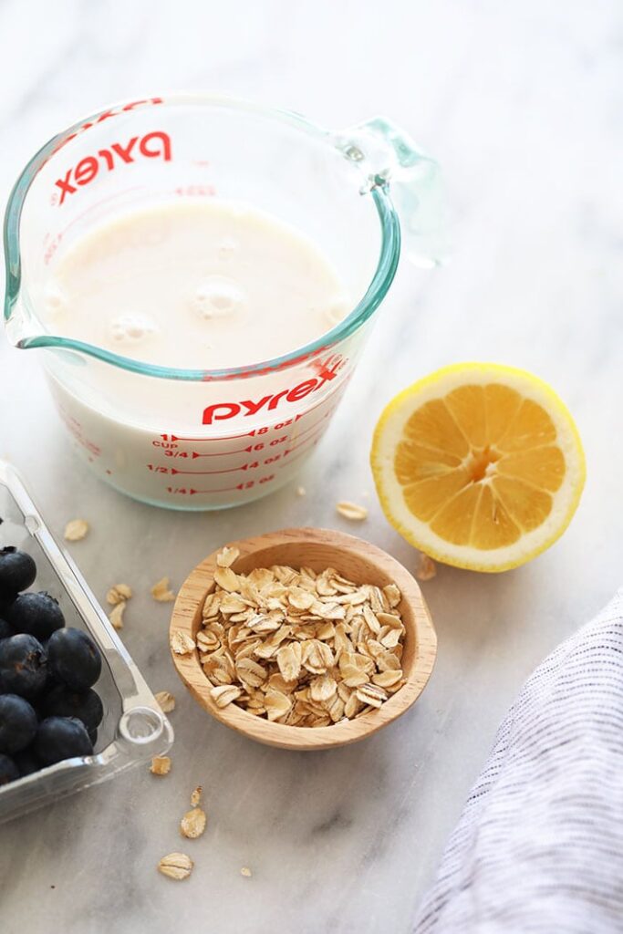 almond milk, rolled oats, lemon, and blueberries on countertop