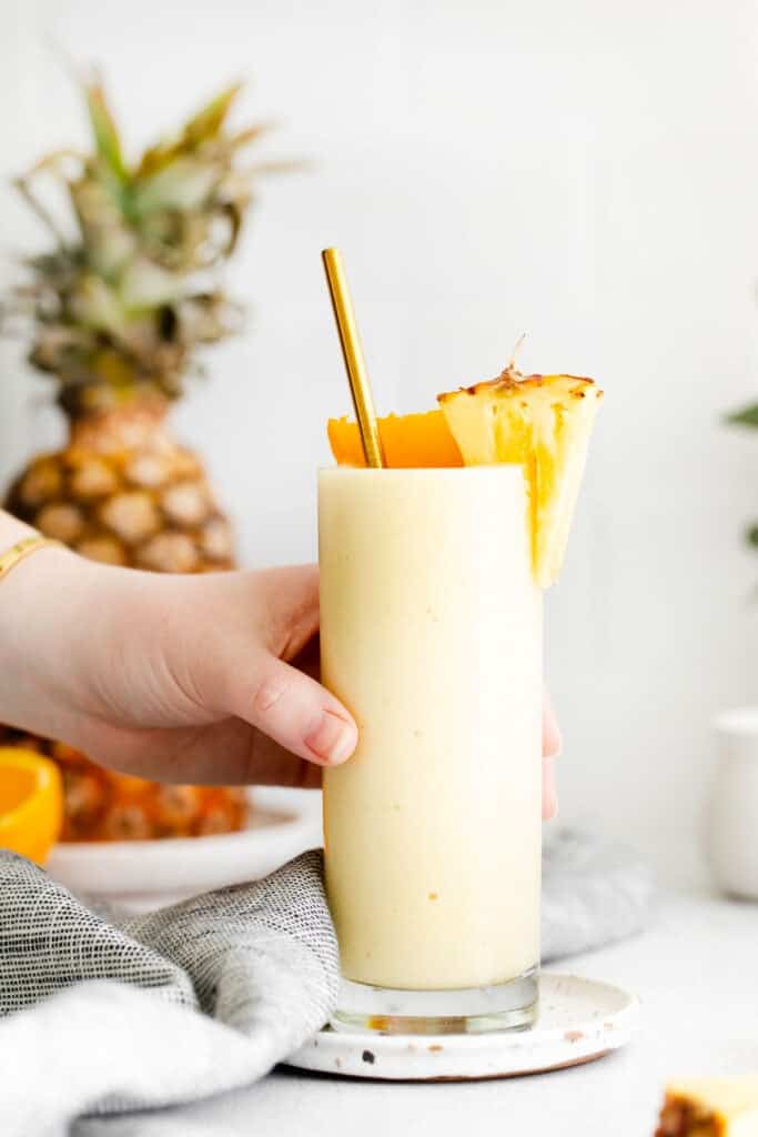 hand holding pineapple smoothie