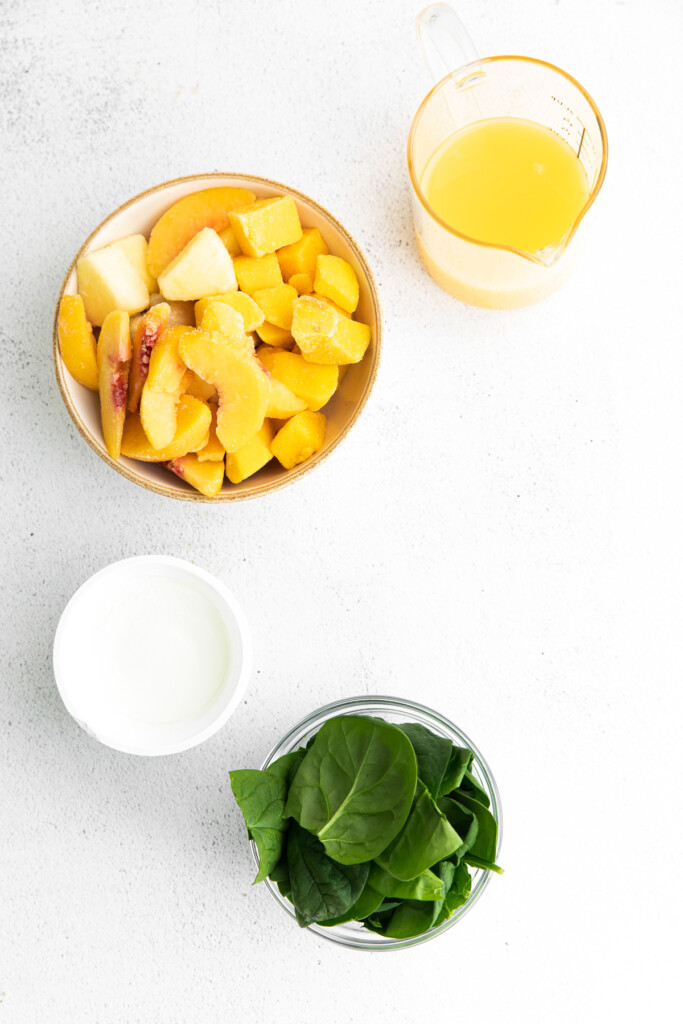 All the ingredients for the spinach smoothie in small bowls. 