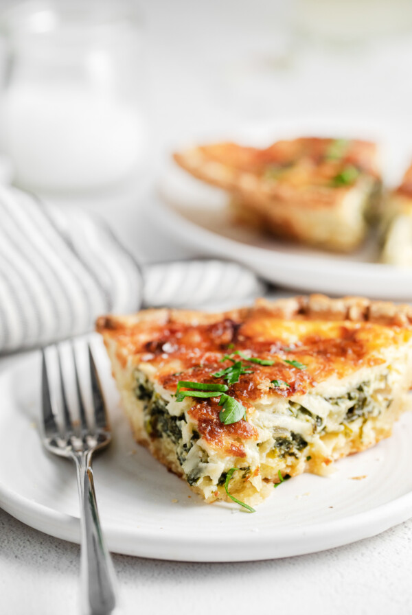 A slice of quiche on a plate.