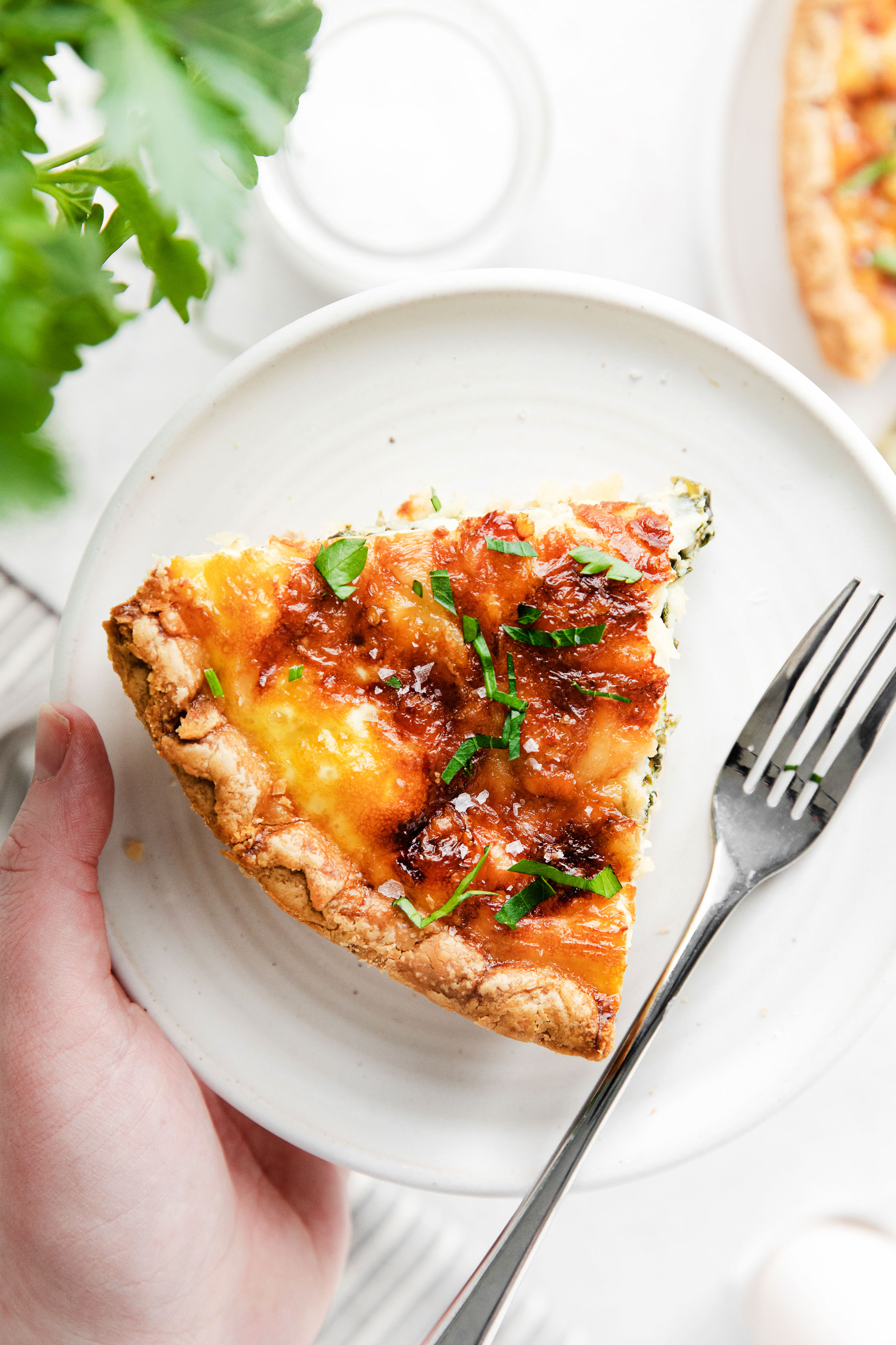 A piece of quiche on a plate. 