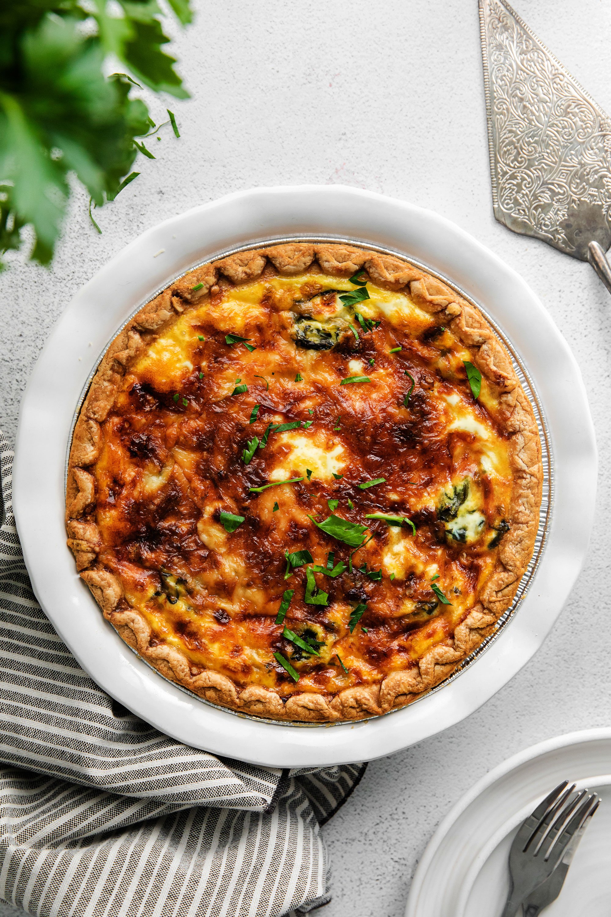 A baked spinach quiche with parsley sprinkled on top. 