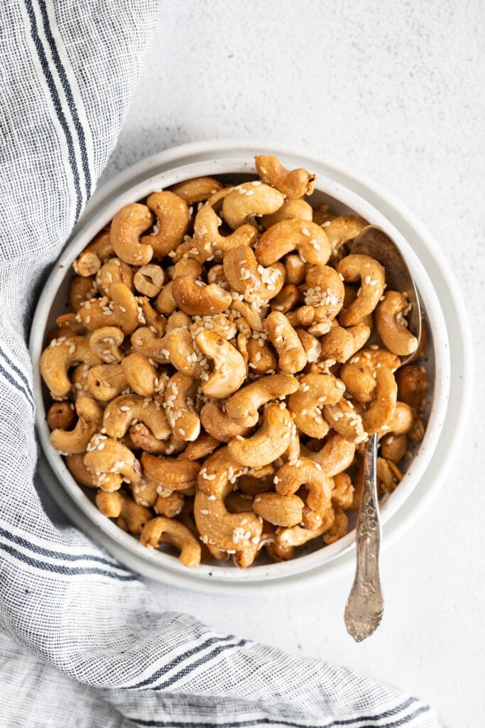 roasted cashews with sesame seeds in a bowl with a spoon