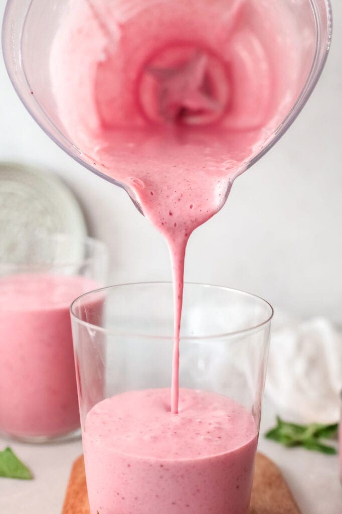 pouring smoothie into glass