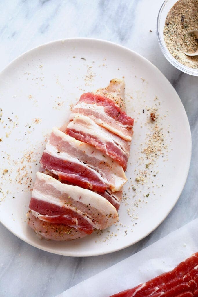 uncooked bacon wrapped chicken on plate