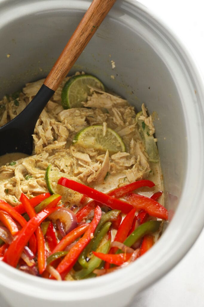 Coconut curry chicken, peppers, and onions in a slow cooker. 
