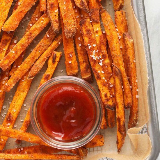 sweet potato fries on a baking sheet with ketchup.